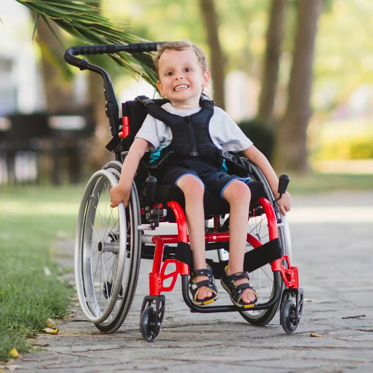 Happy Grant Recipient in Wheel chair on path at the park